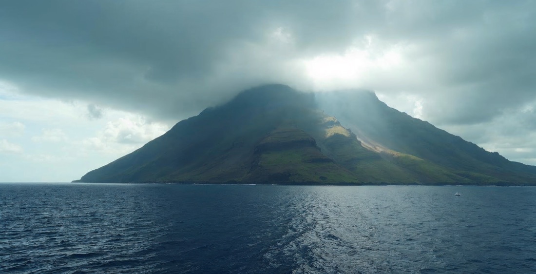 Volcano La Soufrière on Saint Vincent, seen from ocean, moody clouds.